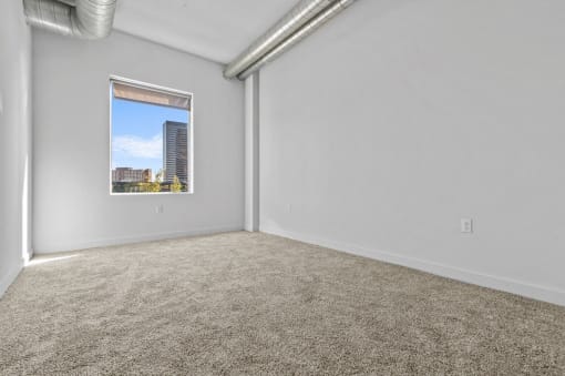 an empty room with carpet and a window