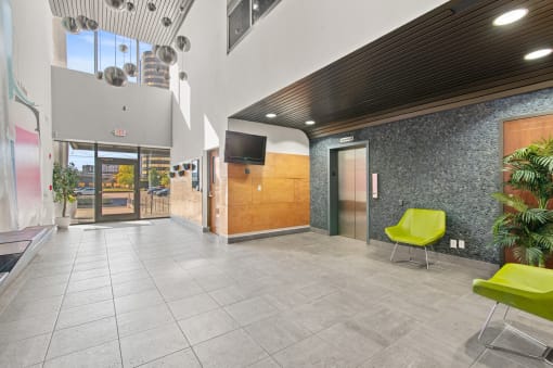a lobby with a door and a television in a building
