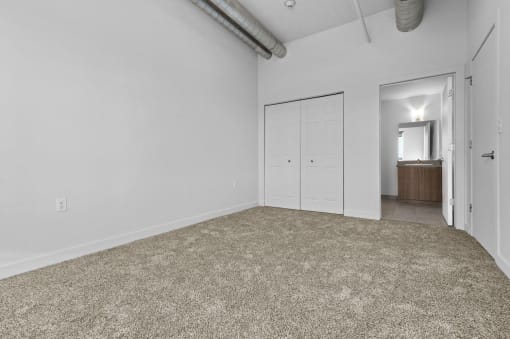 a living room with a carpet and a door to a bathroom