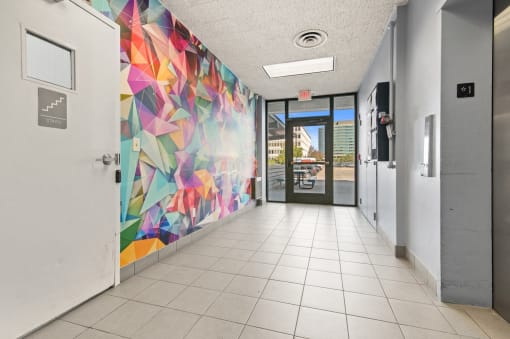 the hallway of a building with a colorful mural on the wall