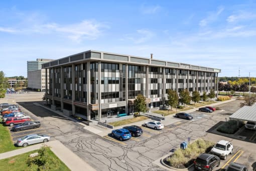 an aerial view of an office building with cars parked in a parking lot
