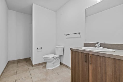 an empty bathroom with a toilet sink and mirror