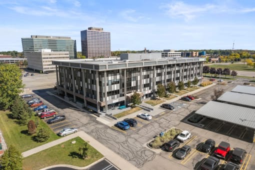 an aerial view of an office building with cars parked in a parking lot