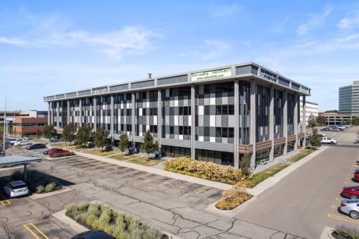 an office building with a parking lot in front of it
