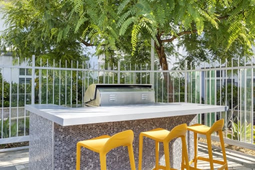 a table with yellow chairs in front of a glass building