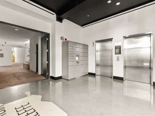 the lobby of a building with columns and paintings on the floor