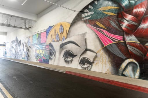 a mural of eyes on a wall in a subway station