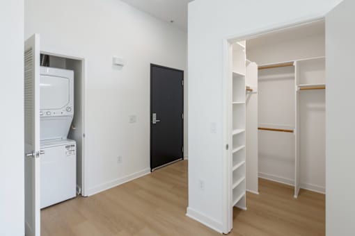 A black door is in the middle of a white wall.