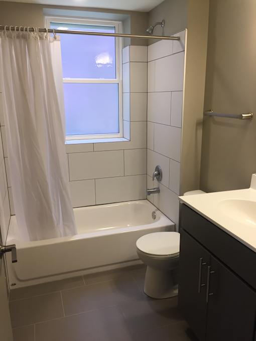 a bathroom with a toilet and a tub and a window