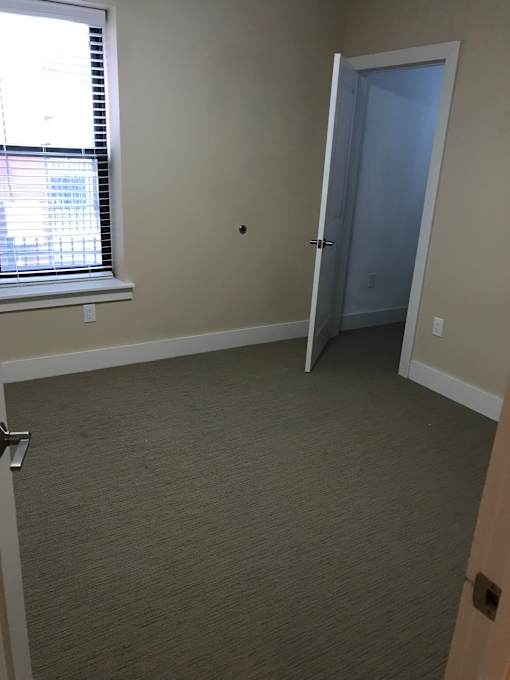 an empty room with a door and a window