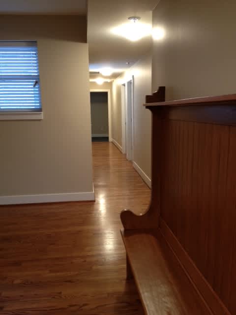 a hallway with a wood floor and a staircase