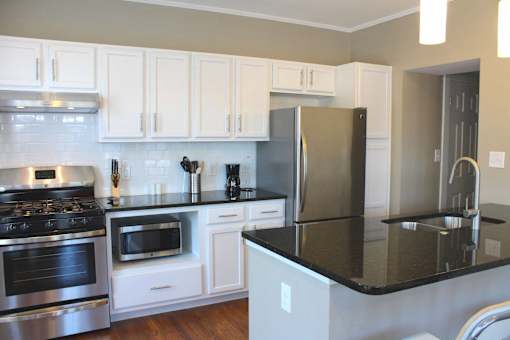 a kitchen with white cabinets and stainless steel appliances