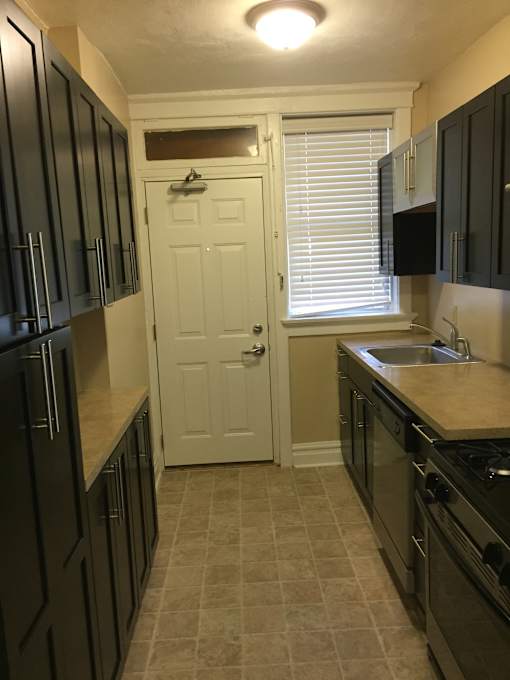 a kitchen with black cabinets and a sink and a door