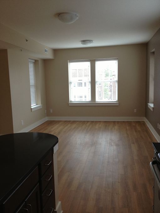 an empty living room with wood floors and windows