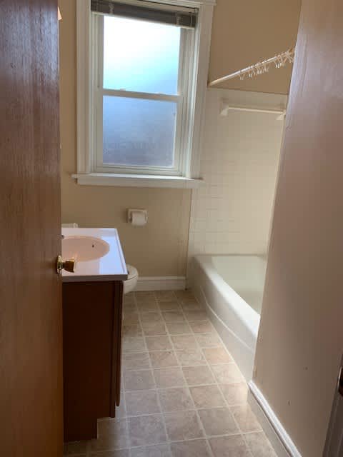 a bathroom with a sink and a tub and a window