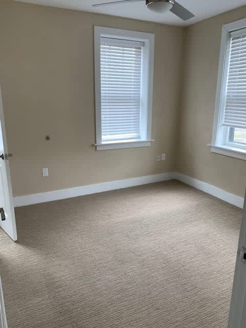 an empty room with two windows and a door