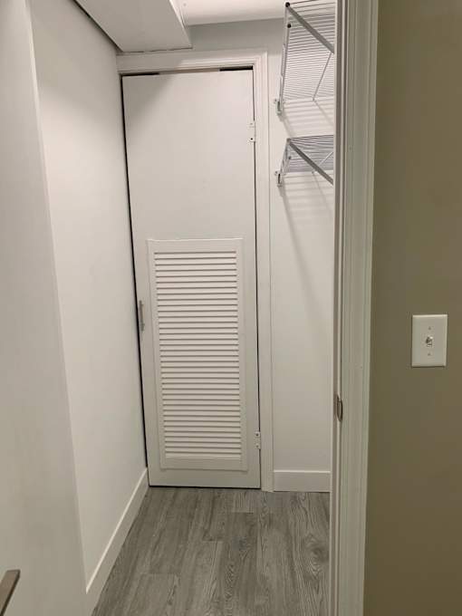 a closet with an opaque closet door and a white closet with a mirrored door