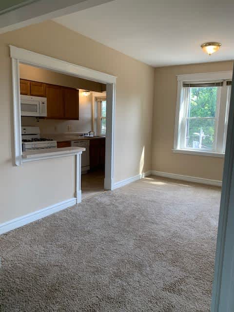 an empty room with a kitchen and a window