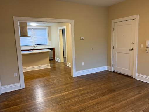 a living room and a kitchen with a wooden floor