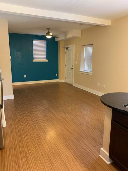 an empty living room with wood floors and a blue wall