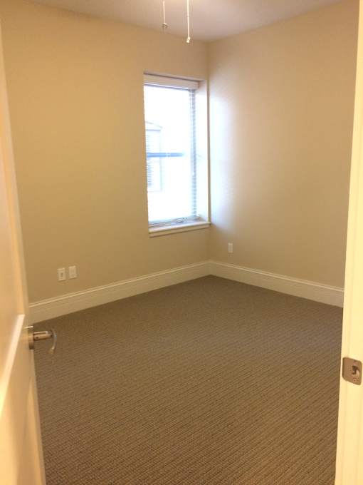 an empty room with a window and a door