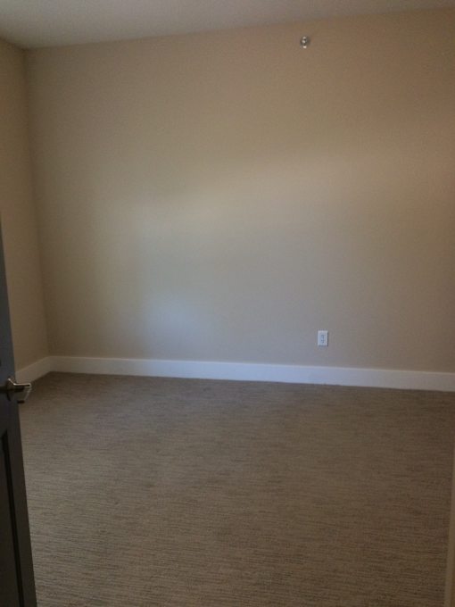 an empty room with a white wall and a door