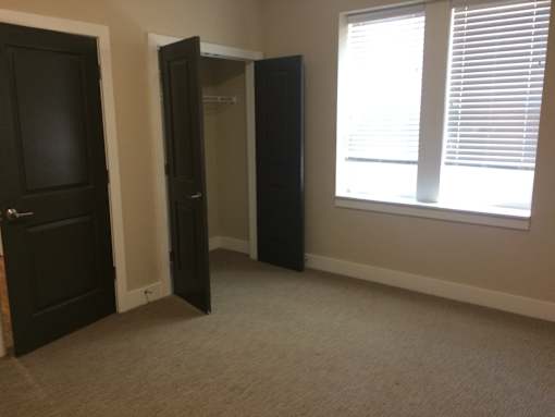 an empty room with two doors and a window