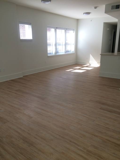 an empty living room with wood floors and a window