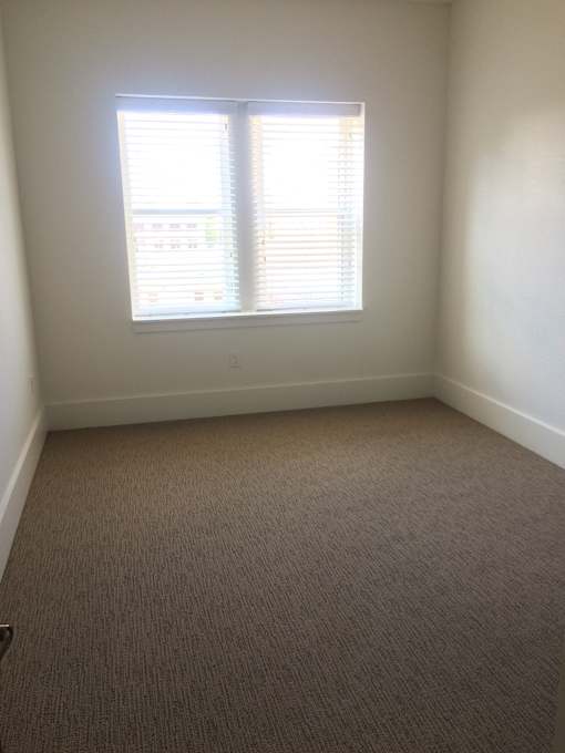 an empty room with two windows in it