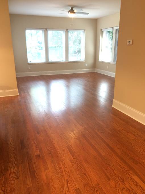 an empty living room with a hard wood floor