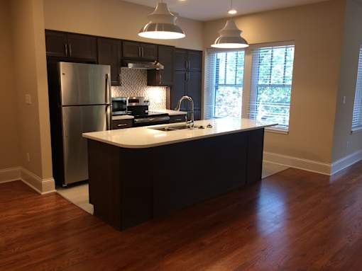 a kitchen with a island and a stainless steel refrigerator