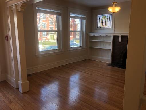 a living room with wood floors and a fireplace