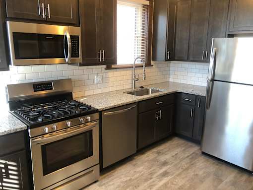 a kitchen with stainless steel appliances and wooden cabinets
