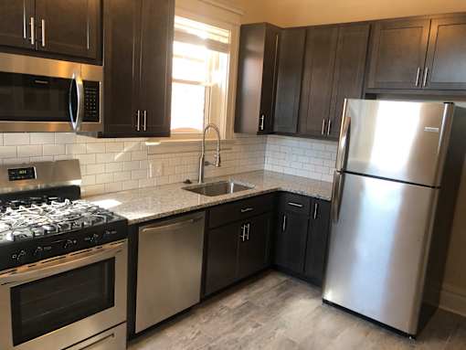 a kitchen with stainless steel appliances and black cabinets
