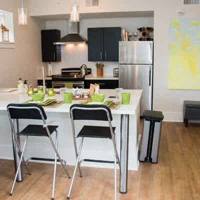 A kitchen with a white table and black chairs.