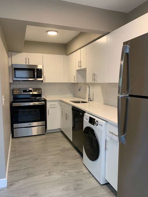 a kitchen with white cabinets and stainless steel appliances