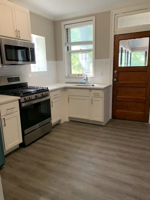 a kitchen with a stove and a sink and a microwave