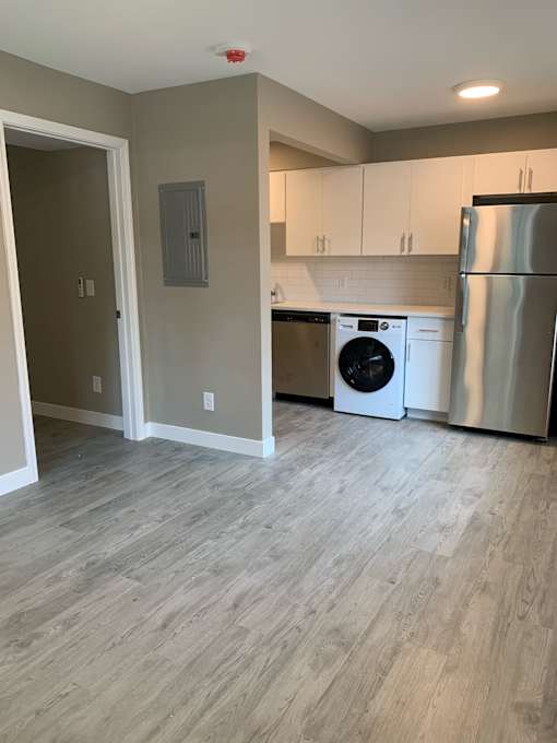 a renovated kitchen with white cabinets and stainless steel appliances
