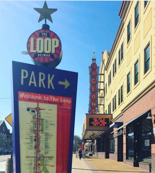 A sign for The Loop Delmar is shown in front of a building.