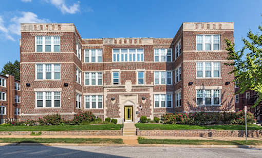 a large red brick building with a yellow front door