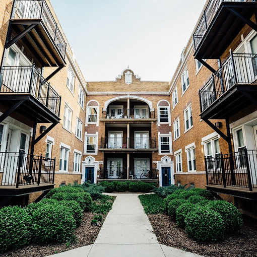 A courtyard surrounded by brick buildings with balconies.