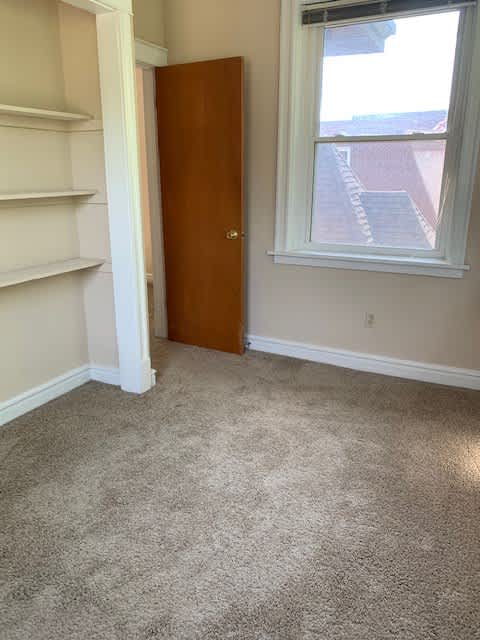 an empty room with a door and a window