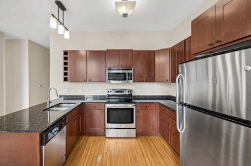 an empty kitchen with wooden cabinets and stainless steel appliances