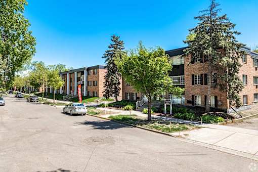 A parking lot with cars and apartment buildings in the background.