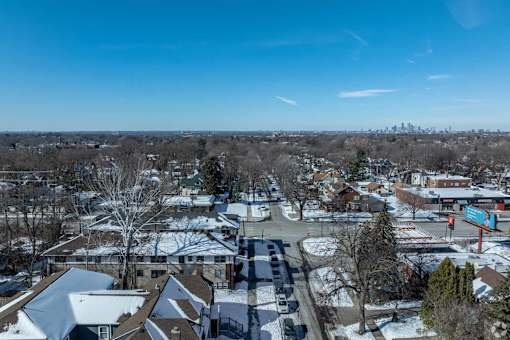 A snowy residential area with houses and a parking lot.