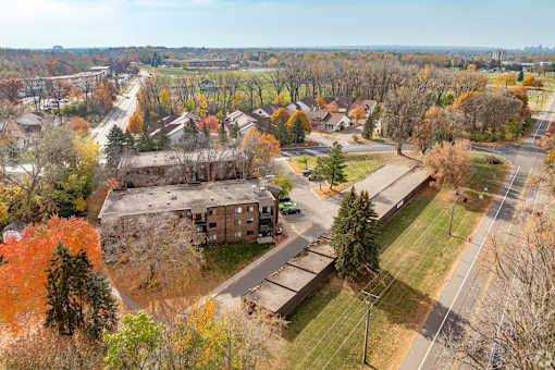 A large building sits in the middle of a grassy area with trees in the background.