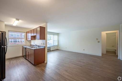 A kitchen with brown cabinets and a black refrigerator.