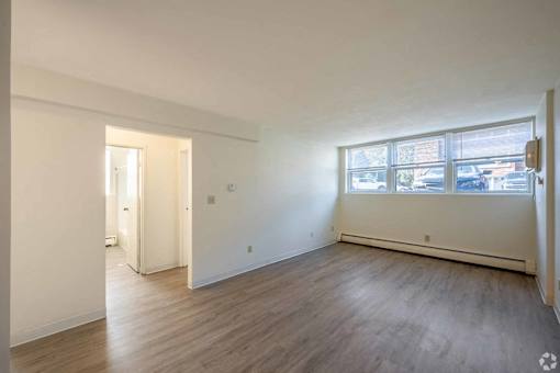 A room with wooden flooring and a large window.