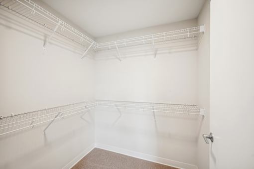 an empty room with white walls and a mirrored closet