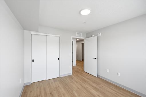 A hallway with a white door and a white wall.